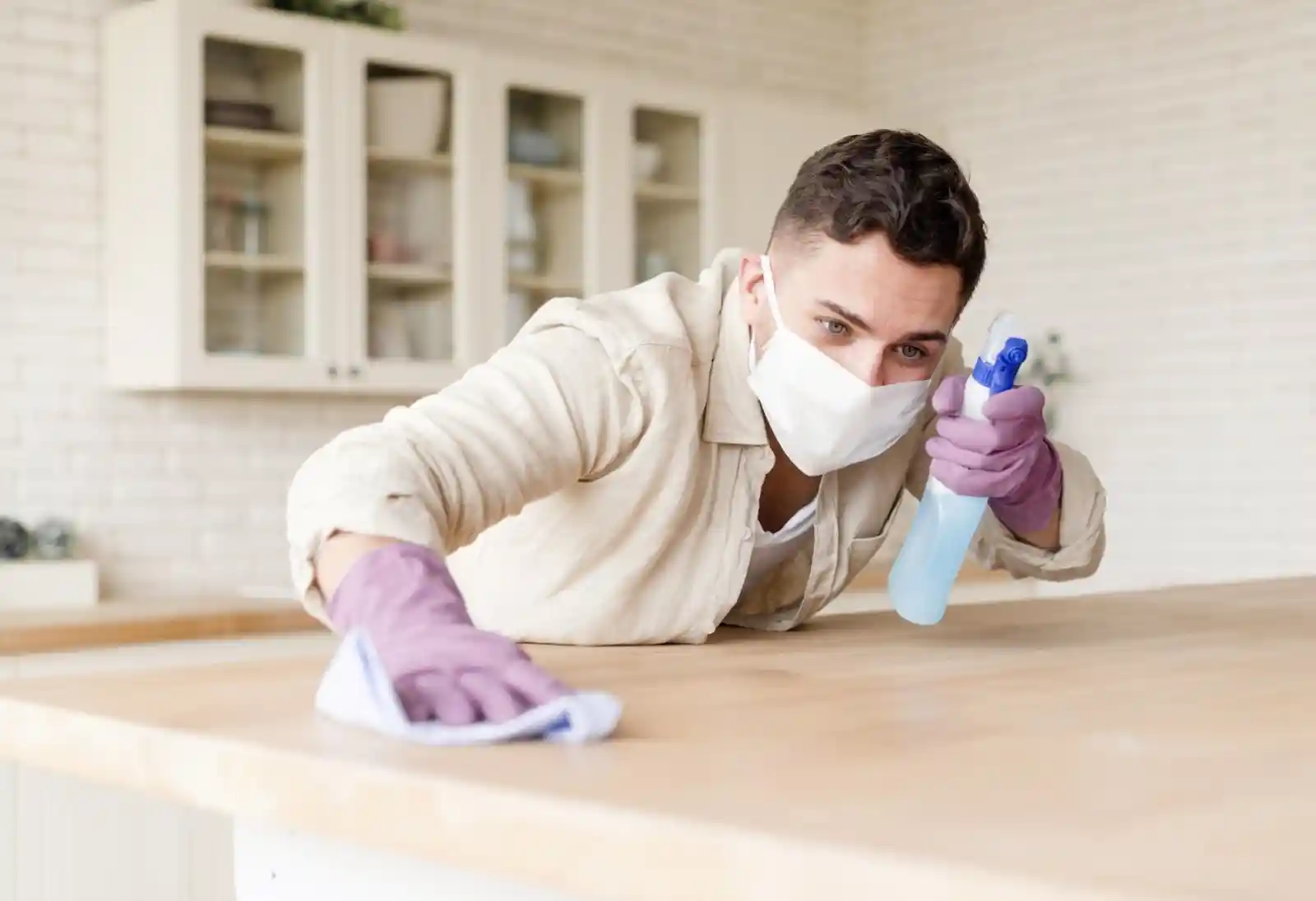 Man sanitising the table in his home.