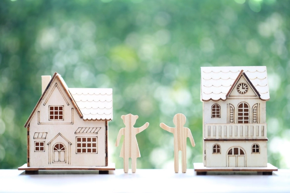 Two wooden houses with wooden neighbours greeting each other, symbolising safety and strong neighbourhood bond.