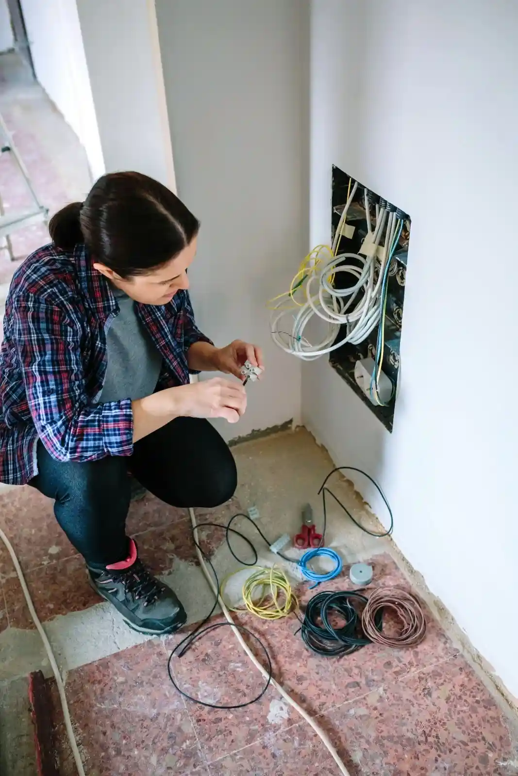 Woman fixing wiring in her home.