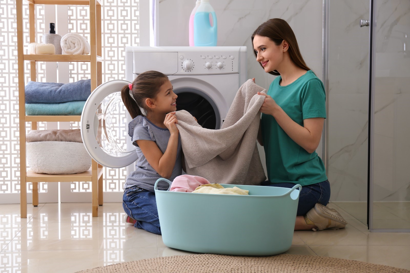 A mother and daughter doing the laundry in the washing machine, a must-have in a home in Goa. A mother and daughter doing the laundry in the washing machine, a must-have in a home in Goa.
