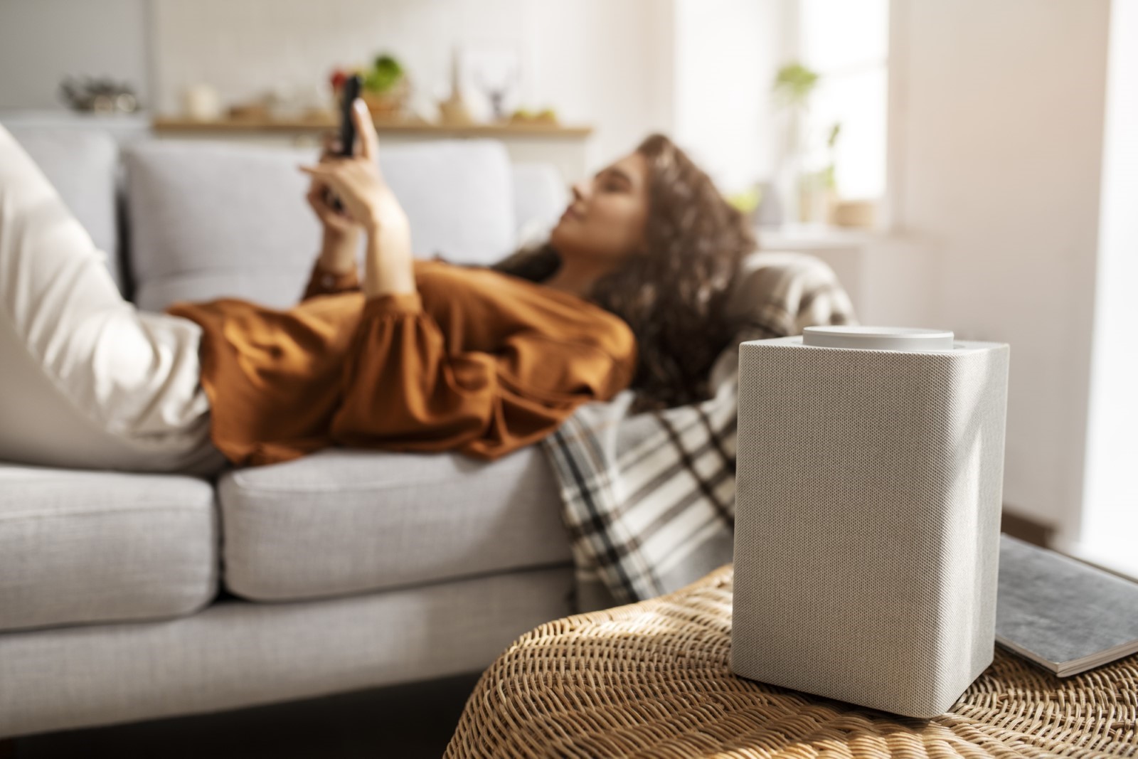 Woman lies on the couch as the dehumidifier gets rid of the moisture in the air. Woman lies on the couch as the dehumidifier gets rid of the moisture in the air.