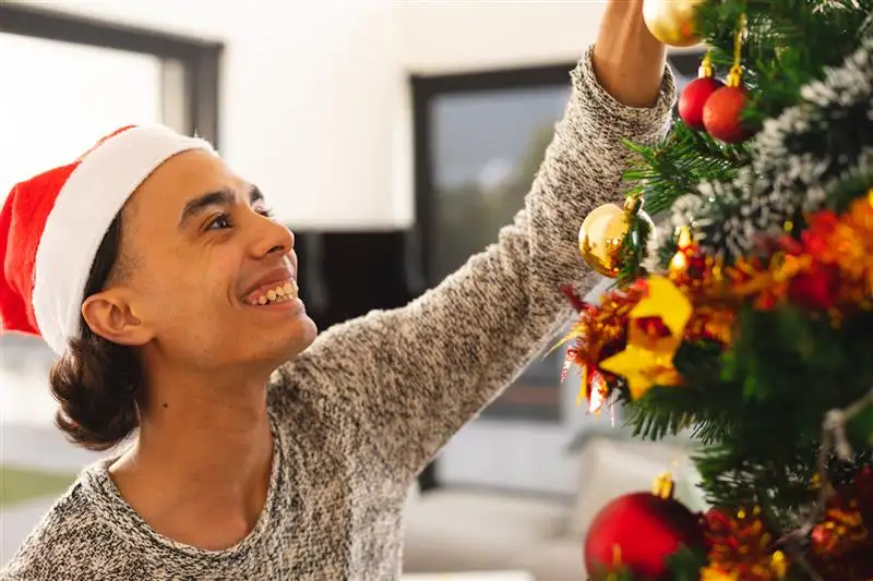 A man decorating his Christmas tree in his home in Goa.