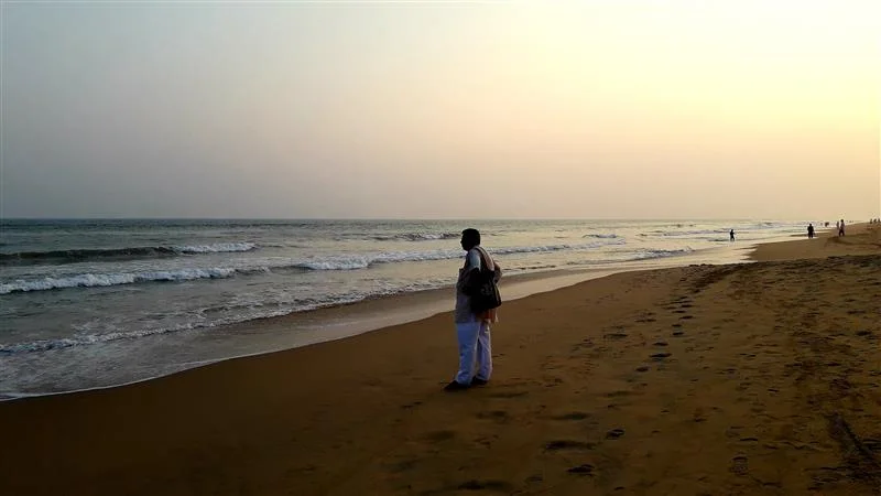 A man taking a walk on a beach in Goa.