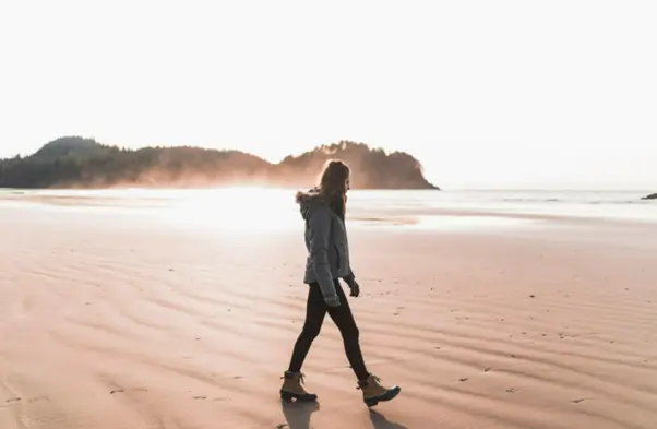 A woman taking a morning walk during winter on a beach in Goa.