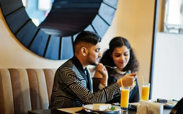 A couple eating food at a cafe near their home in Goa.