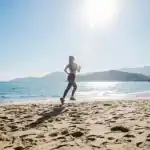 A woman taking a morning run on a beach near a home in Goa