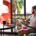 A man enjoying some juice on a hot day in his home in Goa.