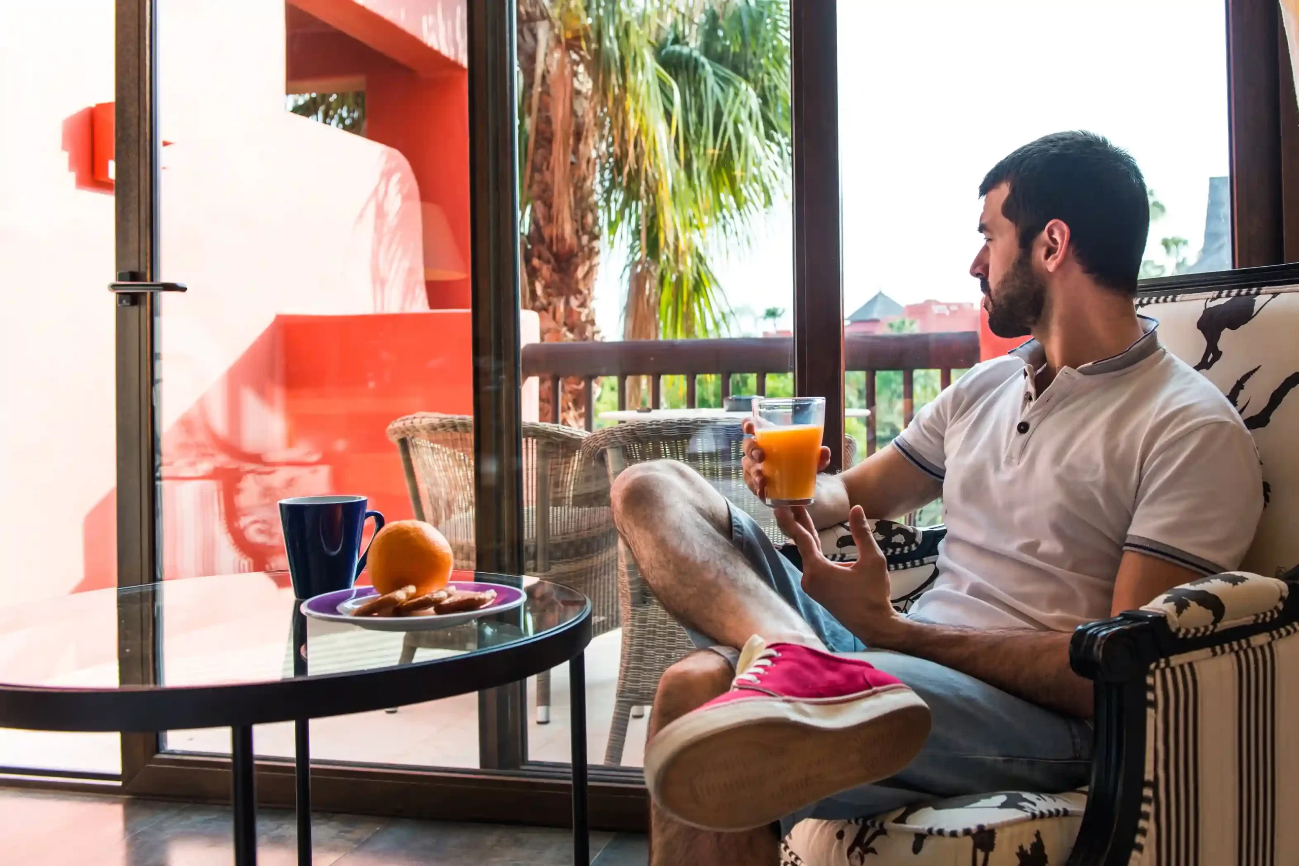 A man enjoying some juice on a hot day in his home in Goa.