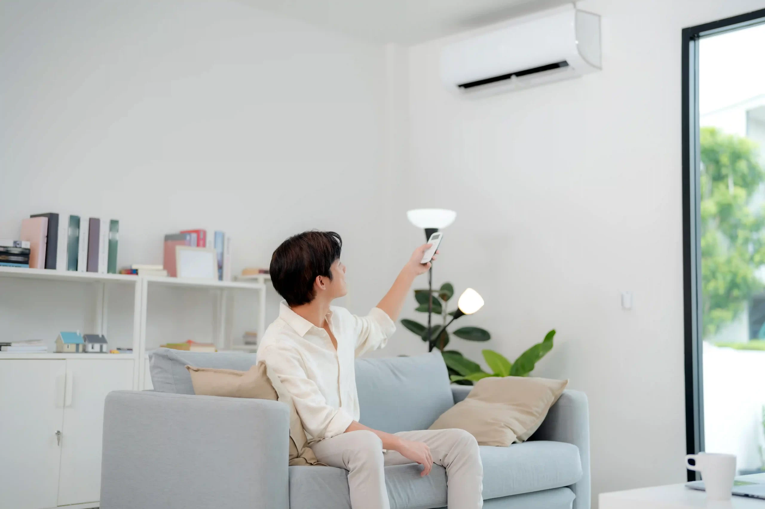 A man turning the air conditioning on during Summer in his home in Goa
