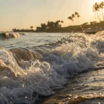 Sunlit waves crashing on a Goan beach near a property in Goa.